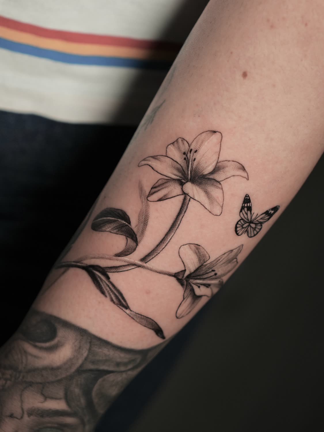 Fine-line lilies and butterfly tattoo